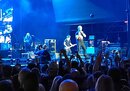 A képen Billy Idol és kísérőzenekara a Budapest Park színpadán egy gyenge minőségű felbontáson keresztül (ha nem lenne világos)(Győri Norbert fotója.)
