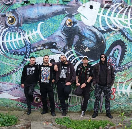 A fotó az interjút követő ljubljanai koncert alkalmával készült. Balról jobbra: Barlog Csaba – gitár, Nikolić Szebasztián – gitár, Ahilej Muki Lak – basszusgitár, Mićo Krnjac – ének, Darko Robović – dob