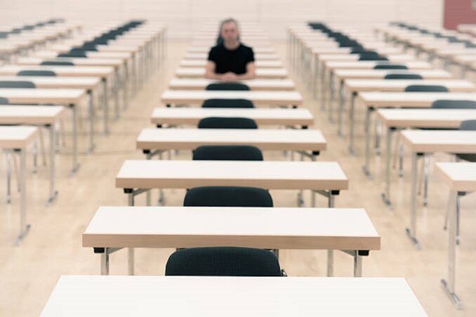 Single person in an examination hall. Selective focus on the first rowlearning, loneliness or the looser. Single person in an examination hall. Selective focus on the first rowlearning, loneliness or the looser.