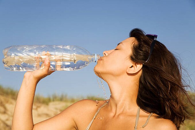 Thirsty woman drinking water from a bottle. Thirsty woman drinking water from a bottle.
